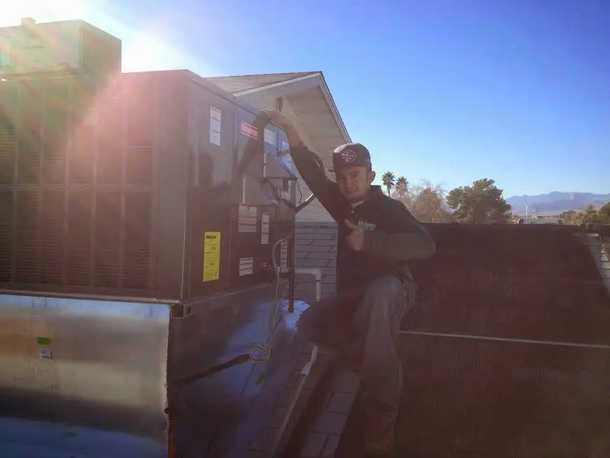 HVAC technician performing Air Duct Repair on a rooftop unit in Ridgefield